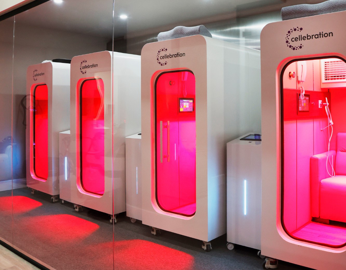 A row of Cellebration hyperbaric chambers glowing red in the treatment room